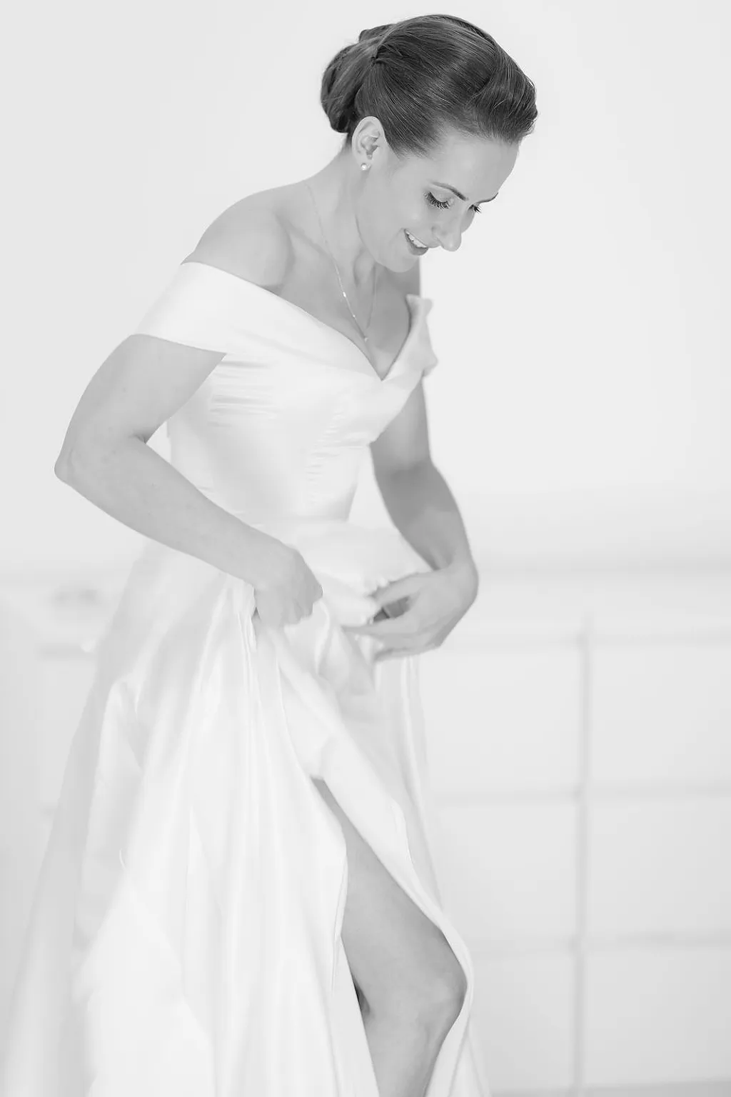Eine Frau in einem hochzeitskleid zieht ihren Rock hoch. Schwarz-weiß-Foto.