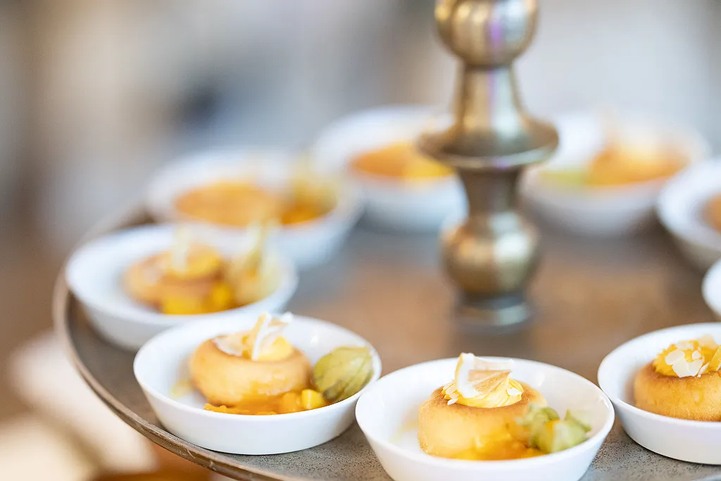 Kleine Desserts mit Zitrusfrüchten und Physalis auf einem Serviertablett.