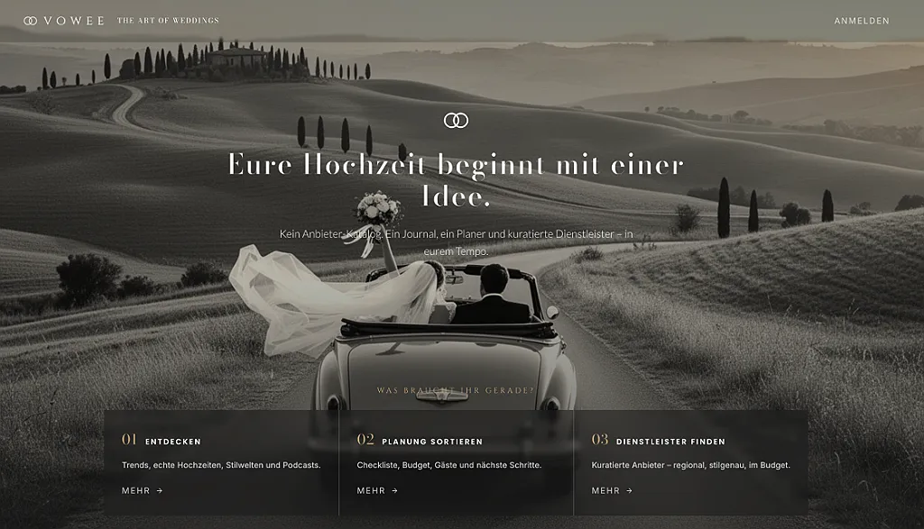 Ein Brautpaar fährt in einem offenen Oldtimer-Auto eine gewundene Straße entlang. Schleier weht im Wind.